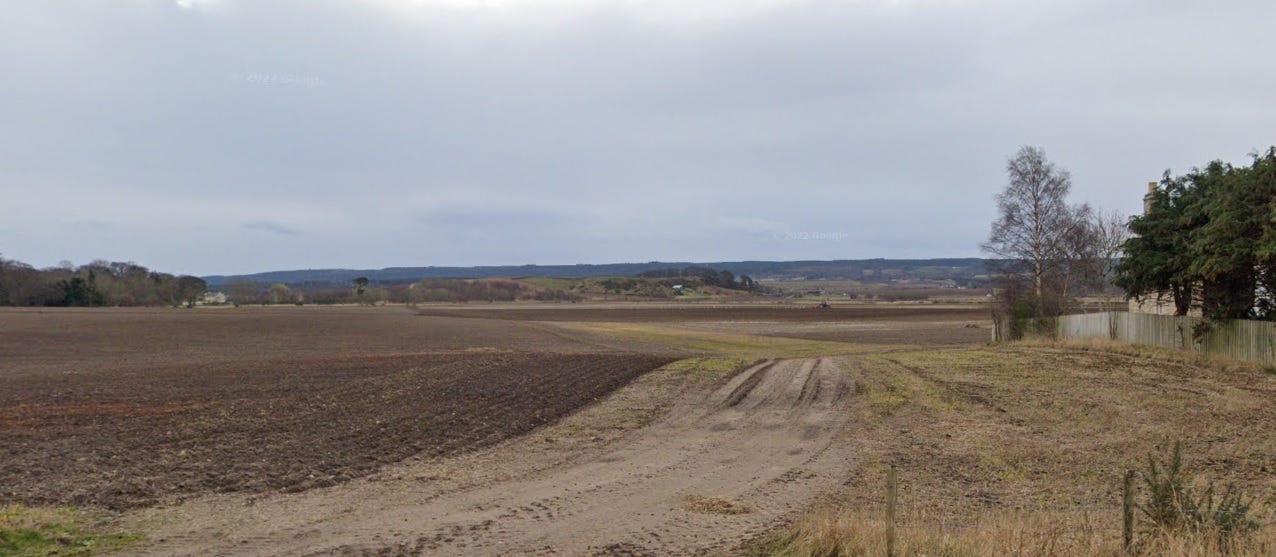 Image from Google Streetview of the view south-east from my old home in Kinloss, looking across flat ploughed fields which the River Findhorn may once have traversed.