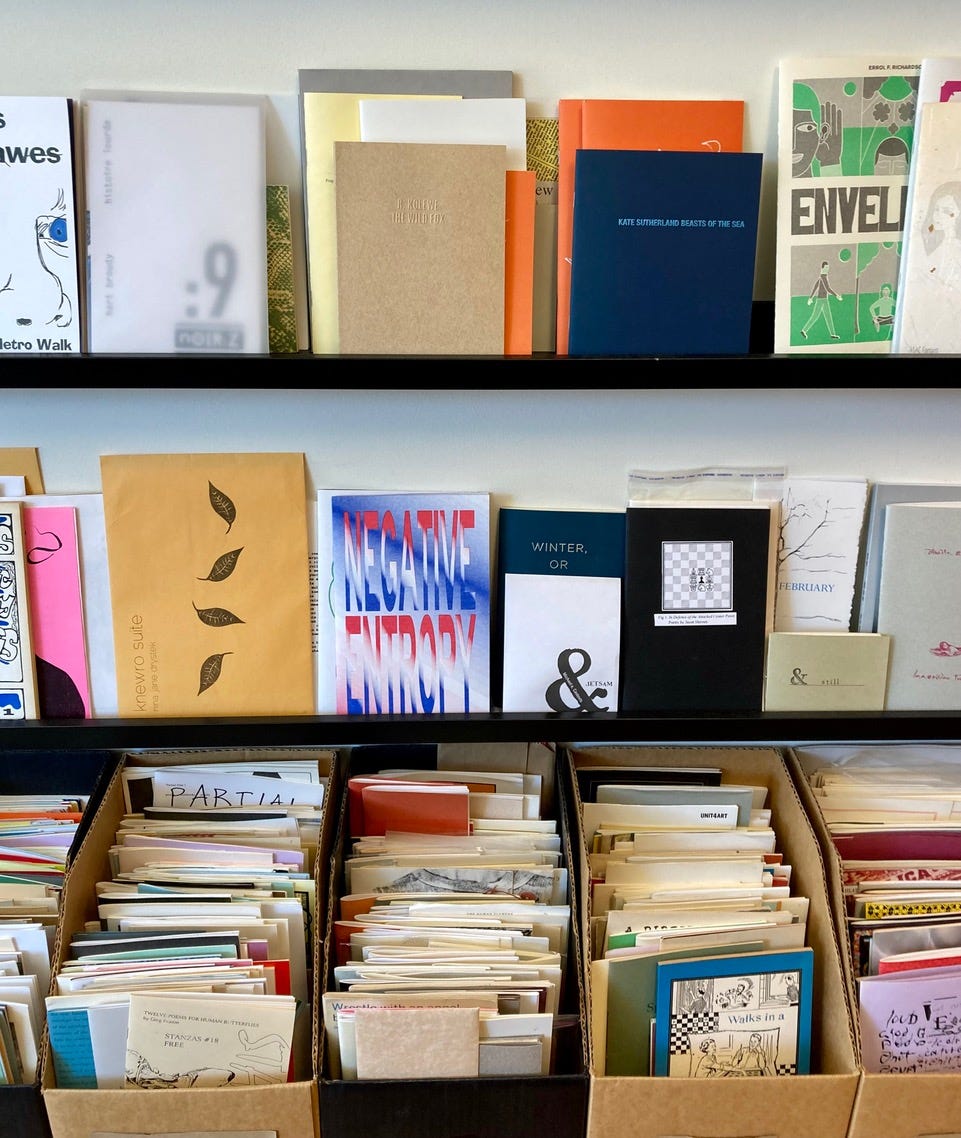 Wall of poetry, divided UK, US, Canadian, with a display of poetic ephemera, a case of rarities and a display rack of chapbooks a top bins carrying the same. 