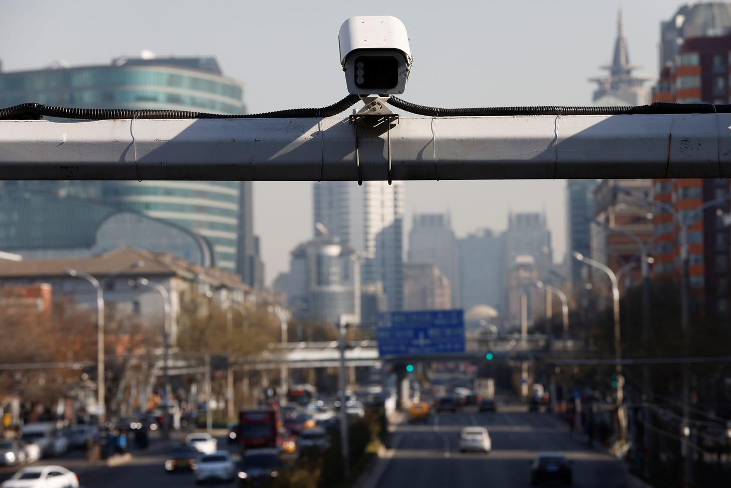 A security surveillance camera overlooks a street as cars drive by in Beijing, China November 24, 2021. Picture taken November 24, 2021. REUTERS/Carlos Garcia Rawlins