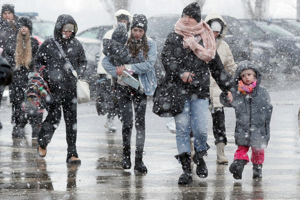 Snow falling as Ukrainian refugees cross the border into Siret, Romania on March 8, 2022.