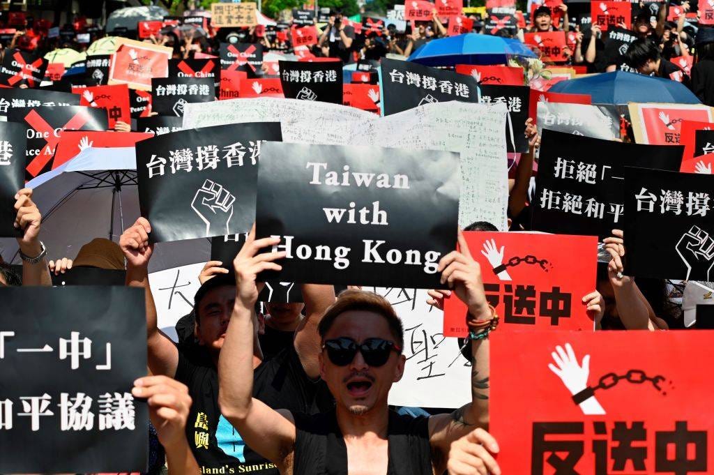 People in Taipei display placards during a demonstration in support of the continuing protests in Hong Kong on June 16, 2019.