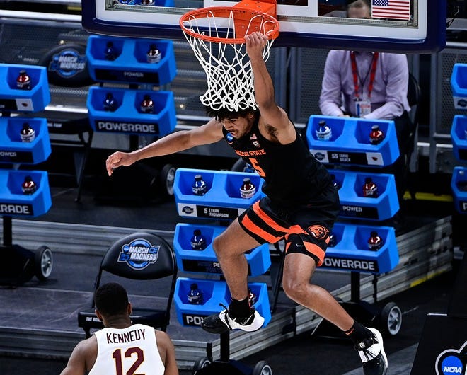 Oregon State guard Ethan Thompson hangs on the rim after dunking against Loyola Chicago during their Sweet 16 game.