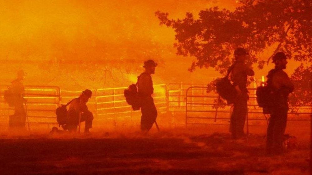 Firefighters look on as the Oak Fire burns in Darrah in Mariposa County, California, U.S. July 22, 2022.