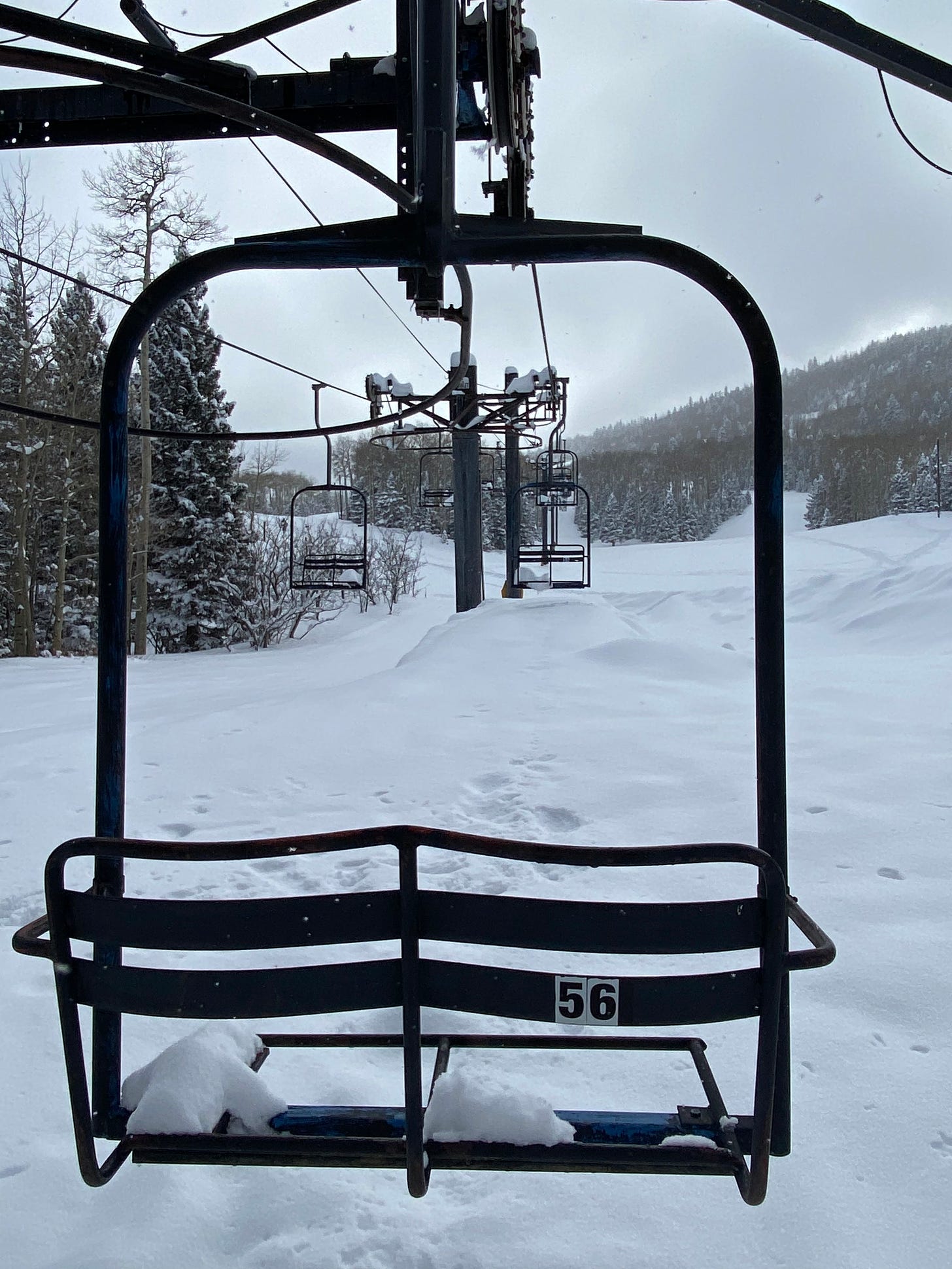 a chairlift chair, covered in snow