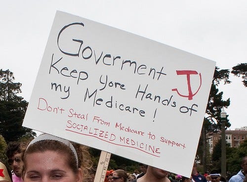 A sign at a protest which says "Government Keep your hands of my Medicare! Don't steal from medicare to support socialized medicine"