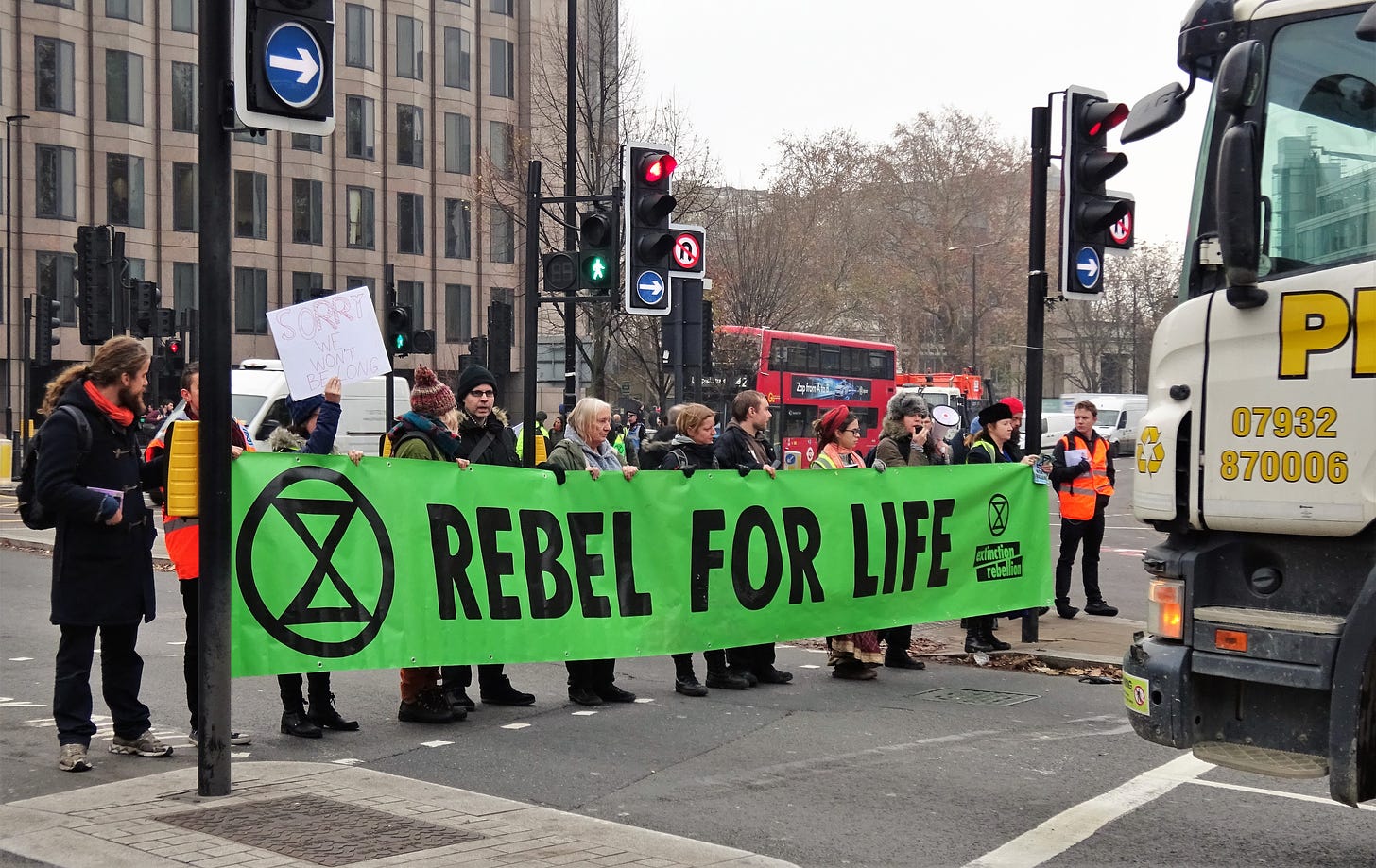 "File:London November 23 2018 (19) Extinction Rebellion Protest Tower Hill.jpg" by DAVID HOLT is licensed under CC BY 2.0