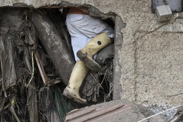 Un residente busca a sus familiares desaparecidos entre los escombros de una casa destruida por un deslizamiento de tierra durante fuertes lluvias en Las Tejerías, estado de Aragua, Venezuela, el 9 de octubre de 2022. (Foto de Yuri CORTEZ / AFP)