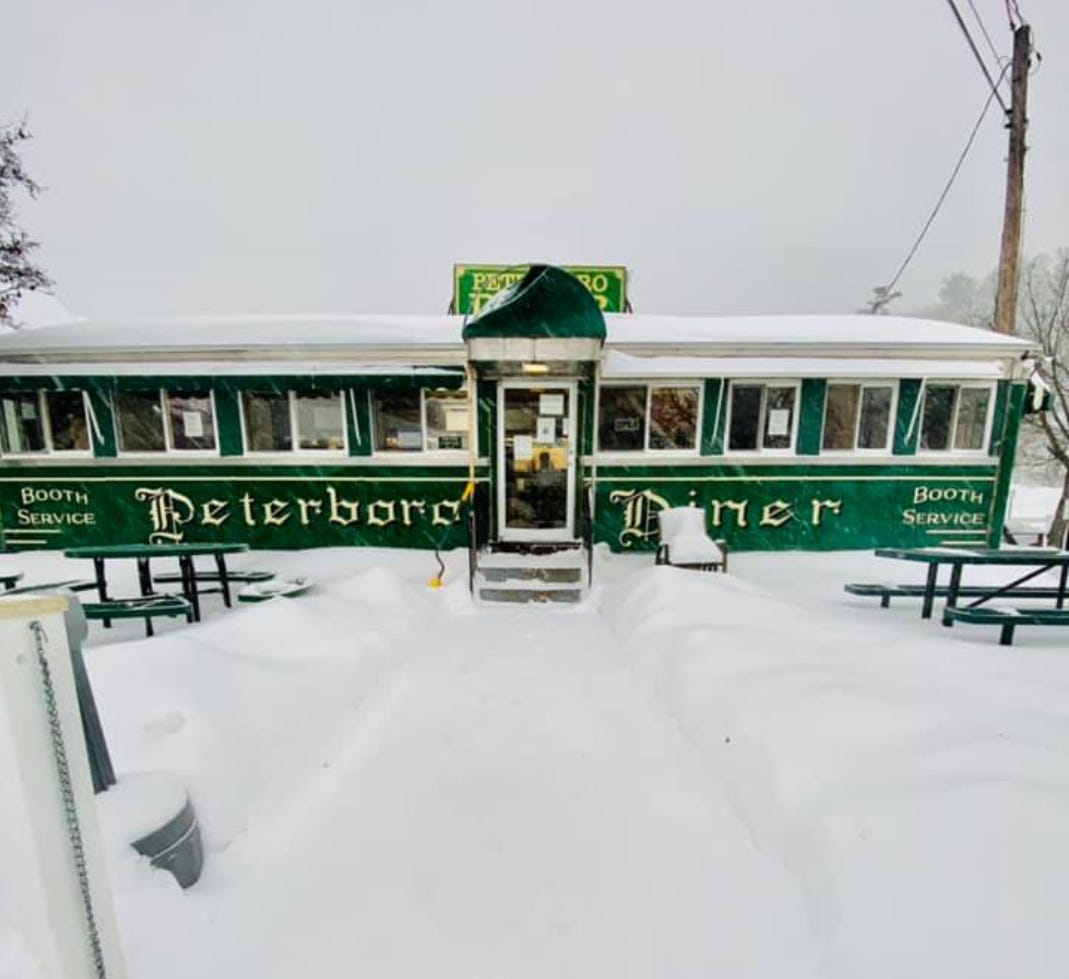 Peterborough Diner covered in snow. It is a single trailer looking place.