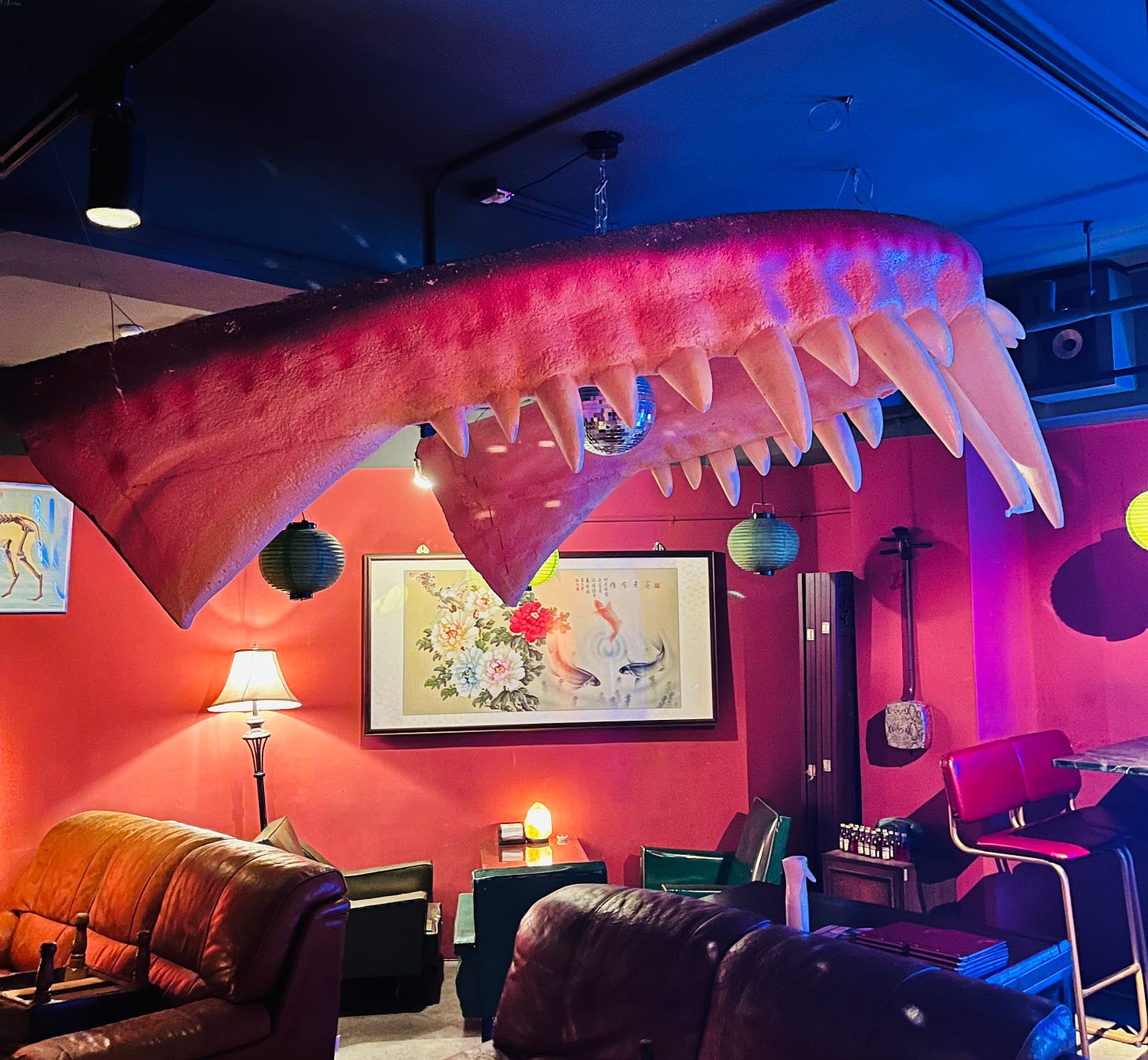 Giant fanged dentures hang over the cozy couches in the dark-ceilinged basement seating area of the Taipei bar Dau