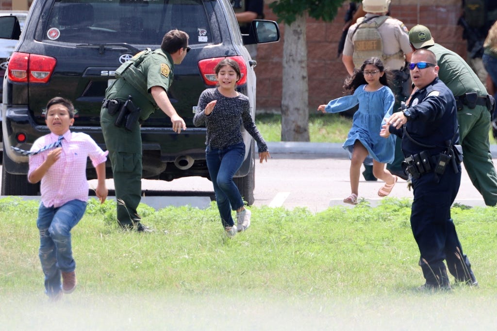 Children run to safety after escaping from a window during a mass shooting at Robb Elementary.
