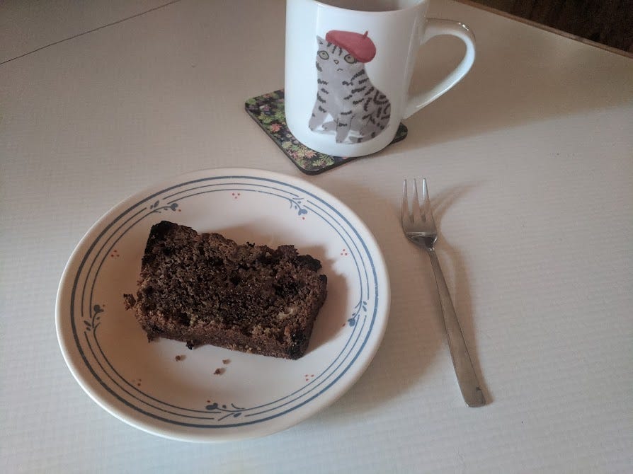 a small plate of spruce tip loaf, a mug of coffee and a small fork
