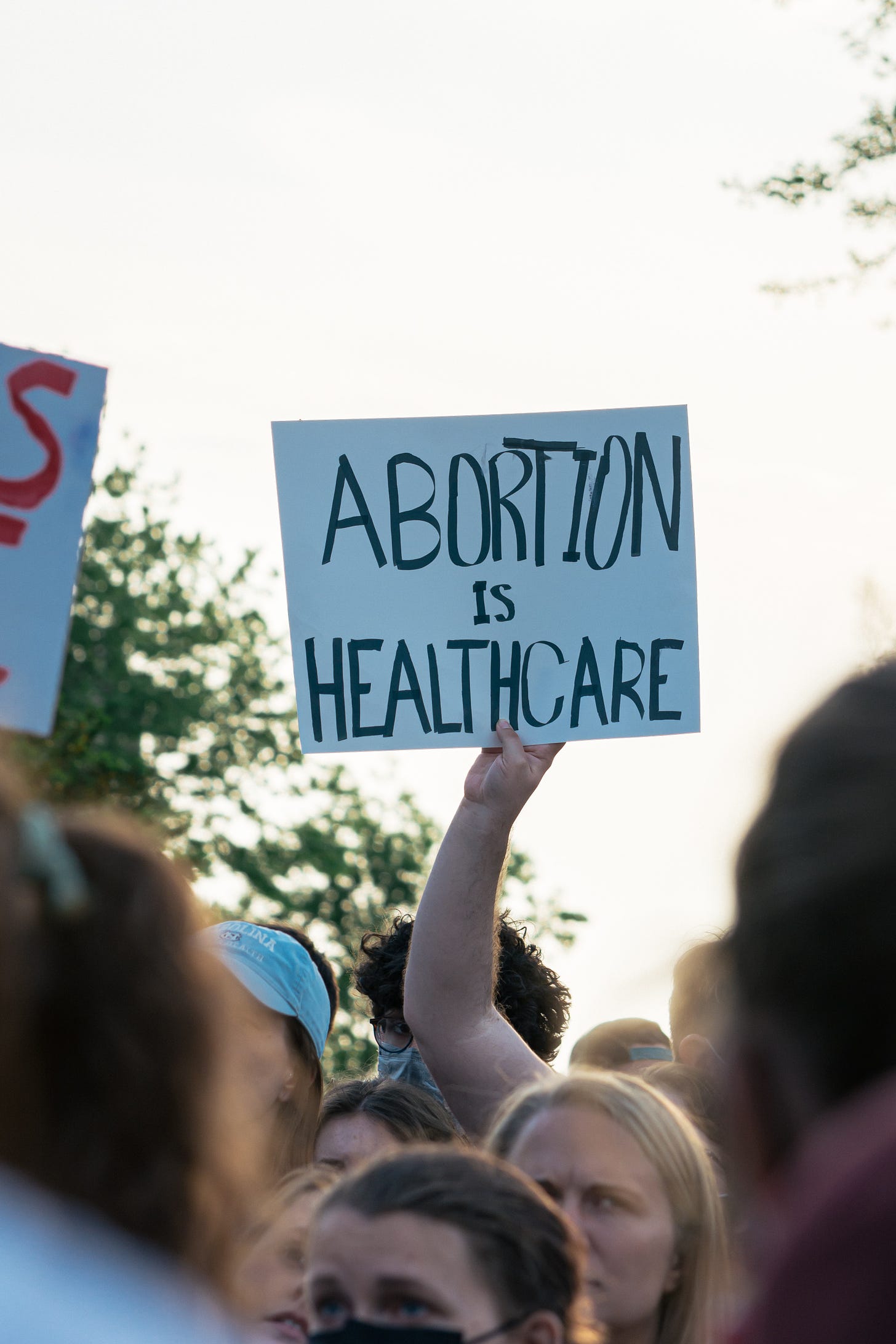 A close up of a handwritten sign at an abortion rights protest. The sign says 'Abortion Is Healthcare'
