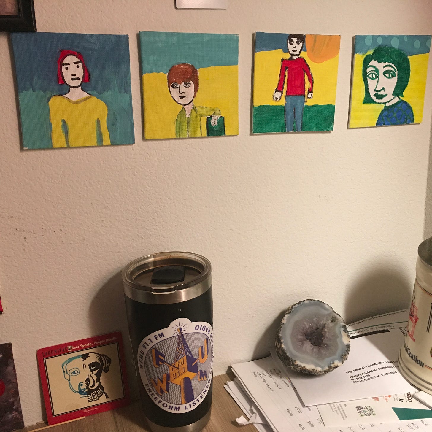 A photo of some paintings and various items on the author's desk.