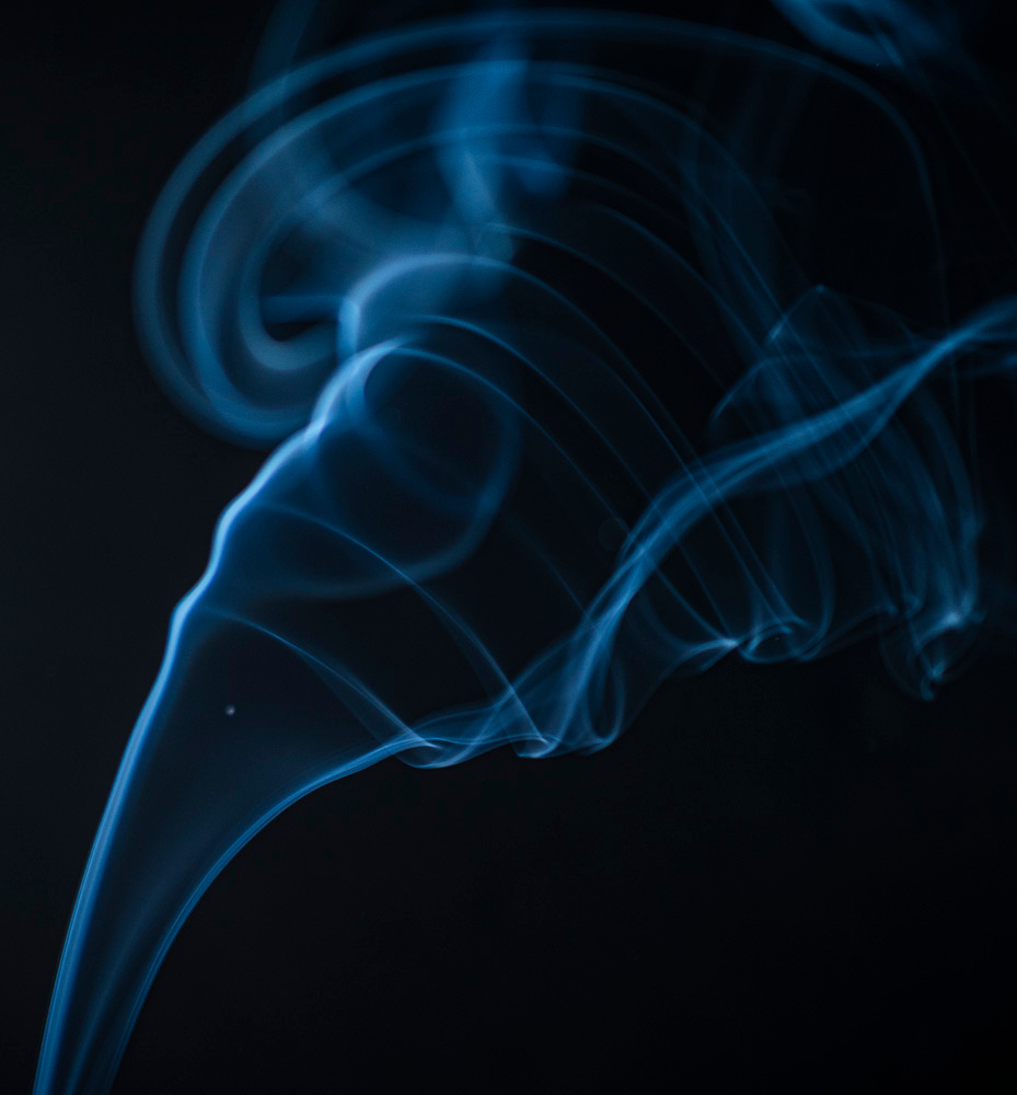 Smoke photographed against a black background; the blue swirls look like a tornado