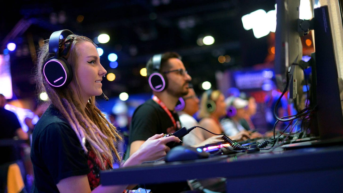 A girl with dreadlocks wearing a SteelSeries headset playing a game at E3