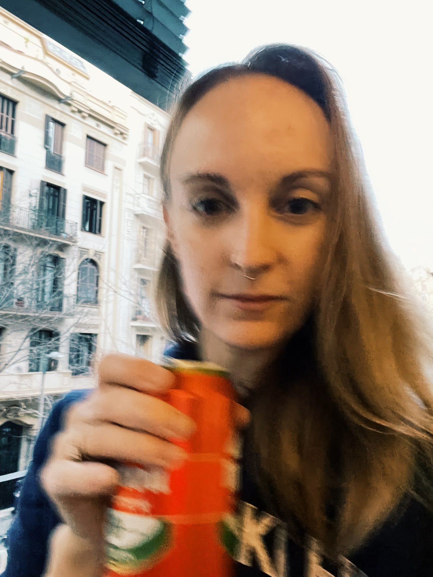 Selfie of the writer holding a can of beer on a balcony. Image is blurry on purpose because that is what is cool now.