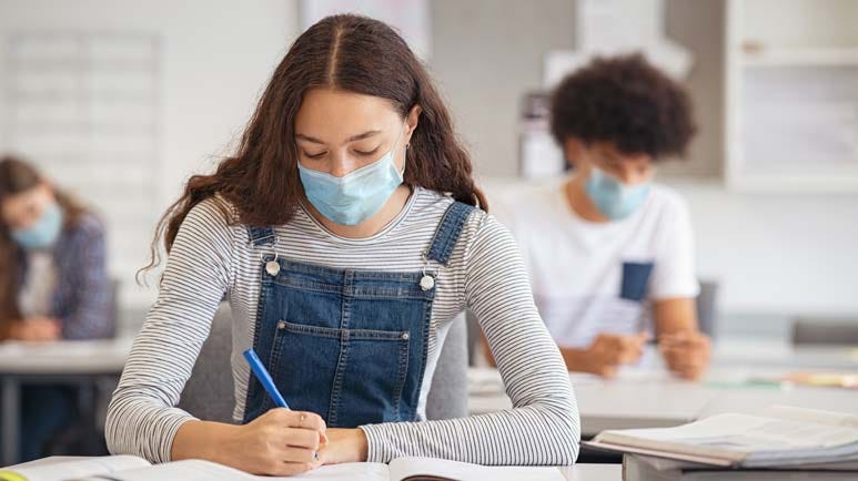 High school girl studying in class with face mask