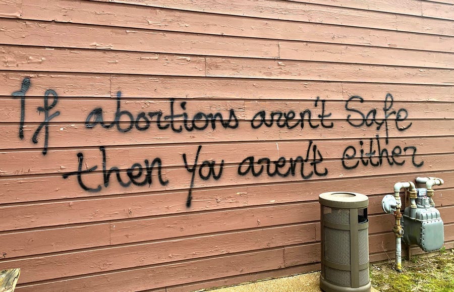 Threatening graffiti is seen on the exterior of Wisconsin Family Action offices in Madison, Wis., on Sunday, May 8, 2022.