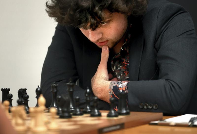 FILE - Chess Grandmaster Hans Niemann, 19, studies the board during a match against Grandmaster Christopher Yoo, 15, at the U.S. Chess Championship in St. Louis on Wednesday, Oct. 5, 2022. Niemann alleges in a federal lawsuit that chess world champion Magnus Carlsen and others destroyed his career by falsely accusing him of cheating.  He is seeking $100 million in damages in the lawsuit filed Thursday, Oct. 20, 2022, in U.S. District Court in St. Louis.  (David Carson/St. Louis Post-Dispatch via AP)