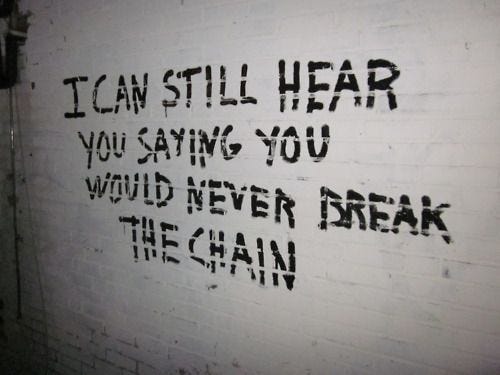 White wall with graffiti in black that says "I can still hear you saying you would never break the chain."