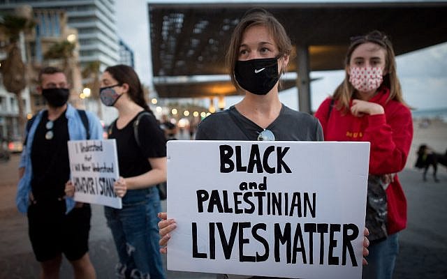 Israelis holds signs during a protest against the death in Minneapolis police custody of George Floyd outside the US consulate in Tel Aviv on June 02 2020 (Miriam Alster/Flash90)