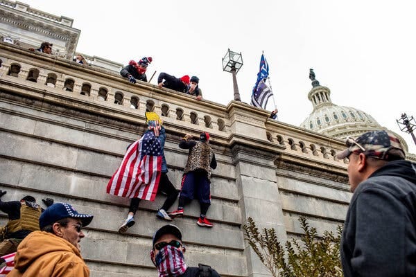 Supporters of President Donald Trump climb up the side of the Capitol to enter in protest.