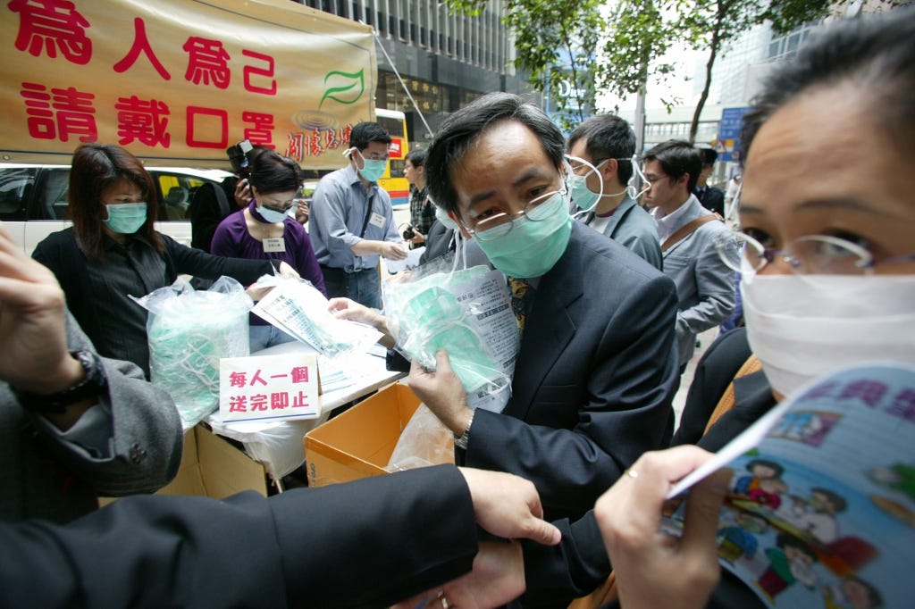 Hong Kong politicians hand out free protective face masks in late March 2003 during the battle to contain SARS. The disease, first contracted by a snake seller in China’s Guangdong province in late 2002, was kept from the public for months. 