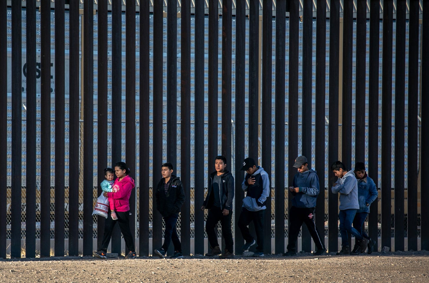 Undocumented immigrants walk along the U.S.-Mexico border wall after they ran across the shallow Rio Grande into El Paso on March 17, 2021 in Ciudad Juarez, Mexico. U.S. immigration officials are dealing with an immigrant surge along the southwest border with Mexico. (Photo by John Moore/Getty Images) Undocumented immigrants walk along the U.S.-Mexico border wall after they ran across the shallow Rio Grande into El Paso on March 17, 2021 in Ciudad Juarez, Mexico. U.S. immigration officials are dealing with an immigrant surge along the southwest border with Mexico. (Photo by John Moore/Getty Images)