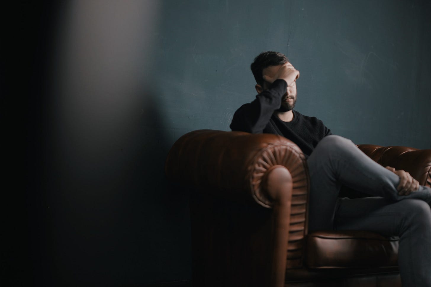 Man sits in a therapist's office recounting his experience with podcasts
