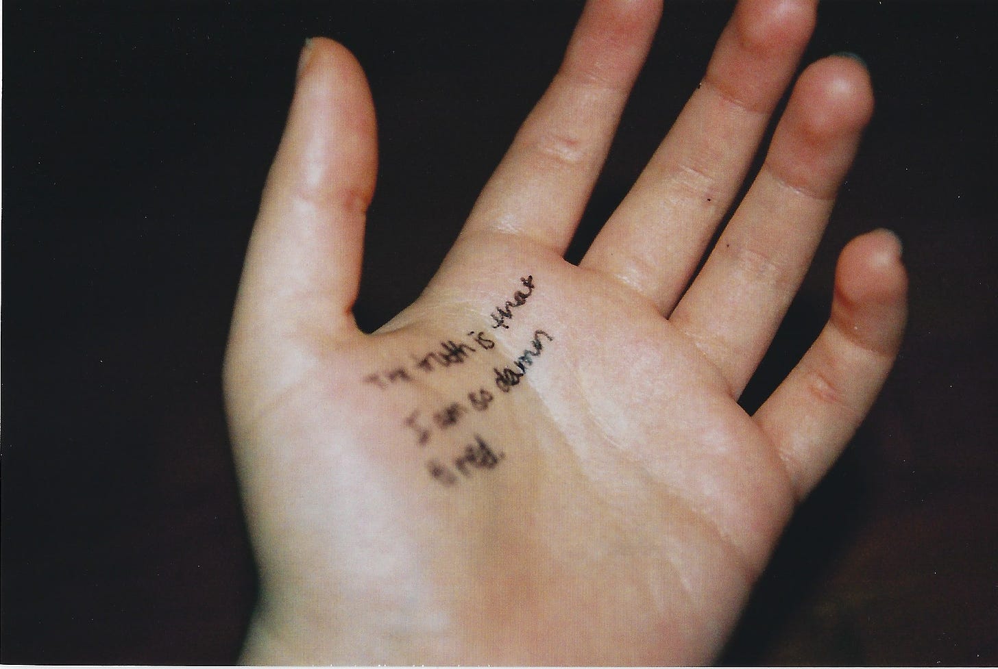 Hand on which is written: "The truth is that I am so damn tired."