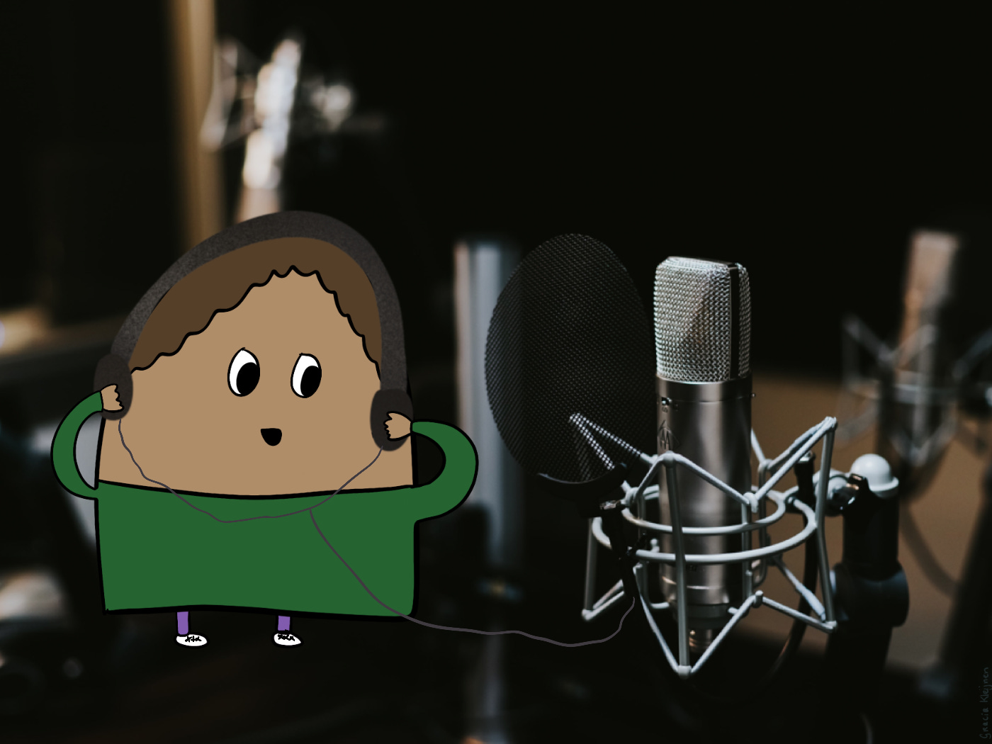 The Blob wearing a headset standing in front of a professional microphone in a recording studio.