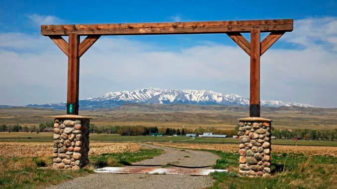 View through Montana ranch entrance to rangeland with a view of central Montana's snow covered Crazy Mountains in the background, The Crazy Mountains rise to over 11,000 feet and are located north of Interstate-90 between Billings and Bozeman Montana; they can be seen for many miles along this stretch of Interstate. (Photo by: Education Images/Universal Images Group via Getty Images)