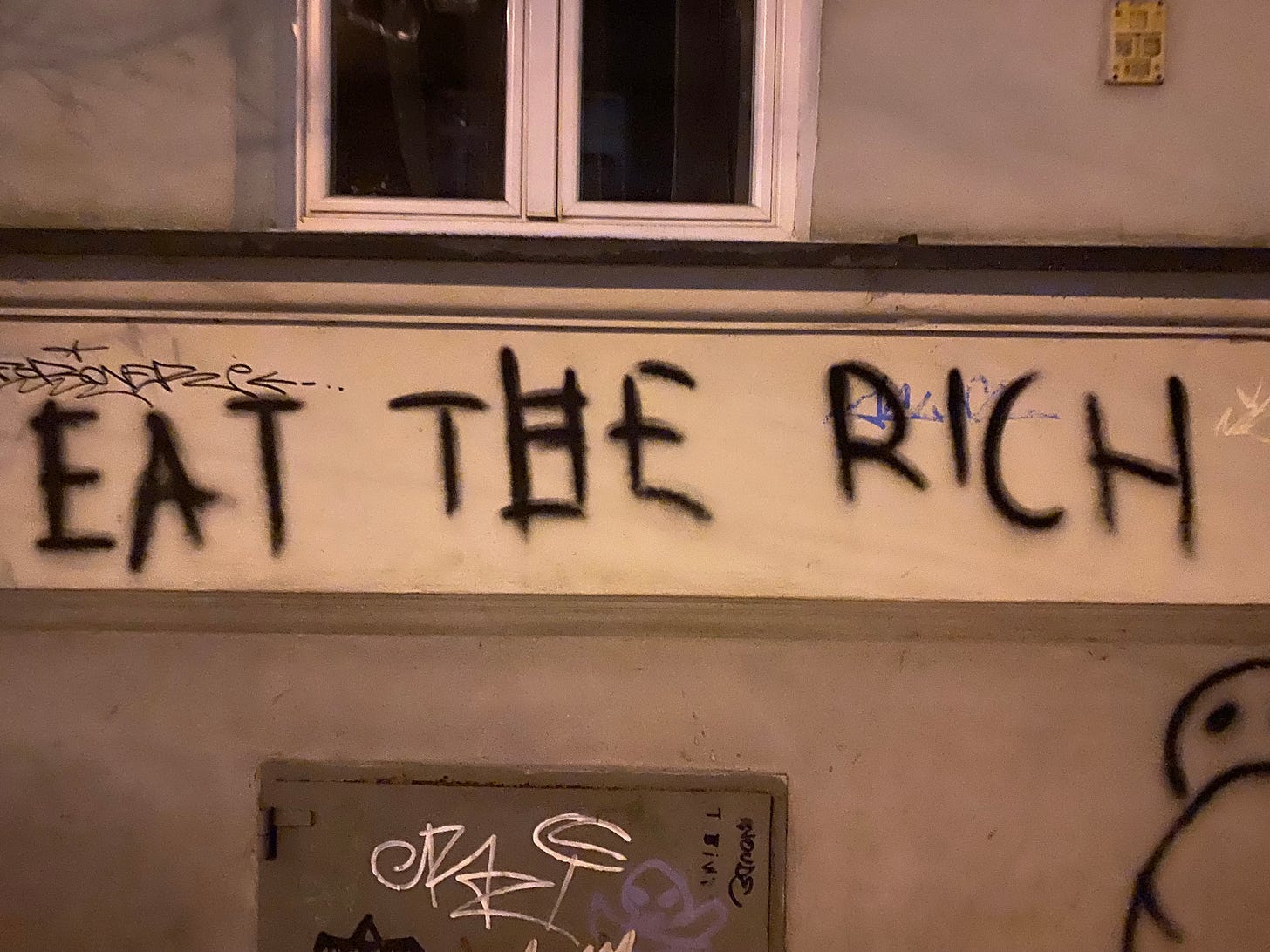 Graffiti, with the text saying "EAT THE RICH"