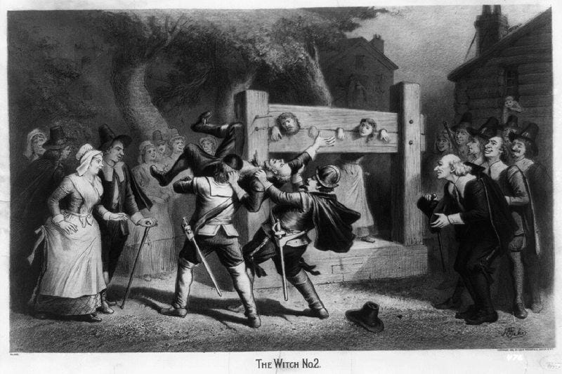 Salem witch trials: Puritans carry an accused witch past public stocks where two other accused witches are locked up