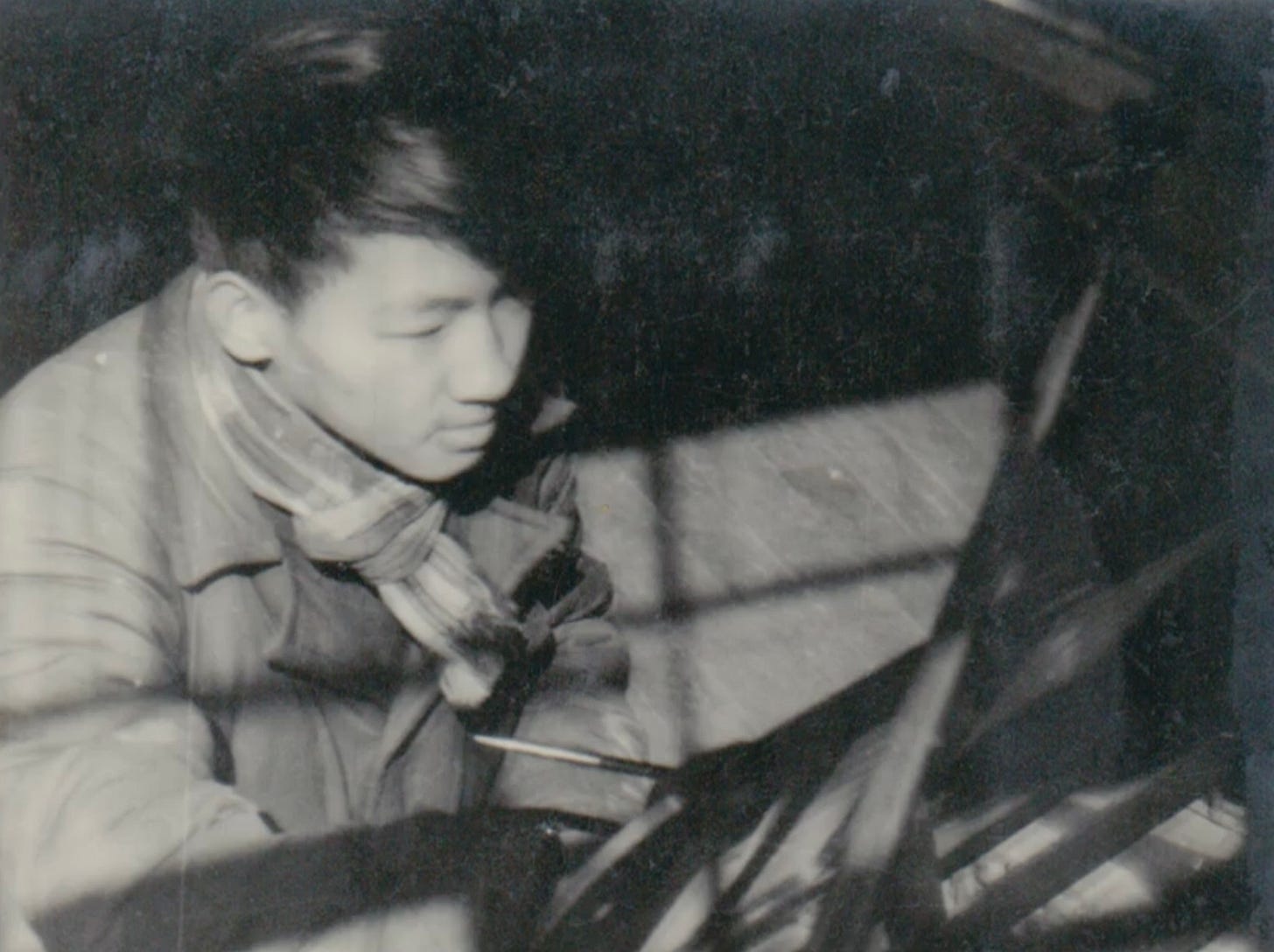 A black and white photo of Chinese composer Wang Lisan composing at the piano during his student days