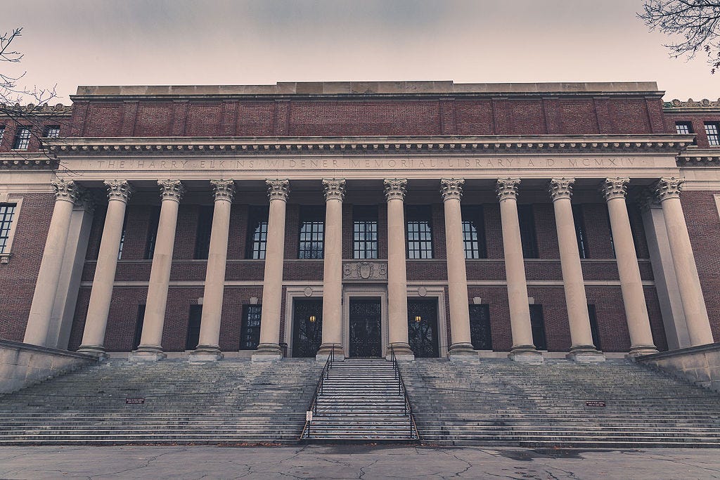 Large Neoclassical brick building with 12 Corinthian columns, sitting atop 25 or so stairs. The relief above the columns reads "THE HARRY ELKINS WIDENER MEMORIAL LIBRARY A.D. MCMXIV"