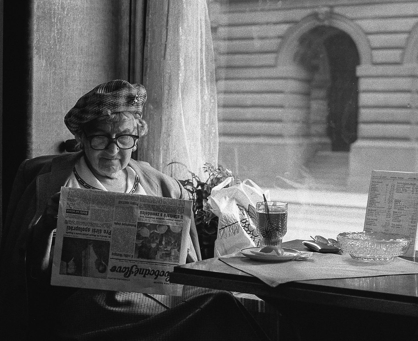 Una donna legge il giornale in un bar