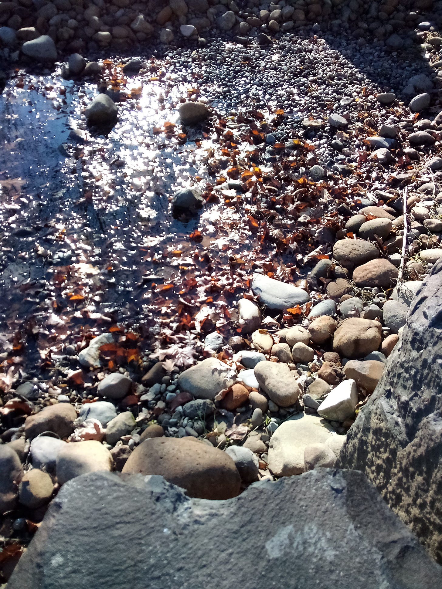 Photo of sunshine on water flowing over rocks