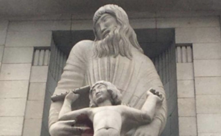 A black and white shot of the sculpture. Prospero and Ariel’s expressions are smiling even though their relationship in the Shakespeare’s play is contentious and they never smile while together. Prospero has an inward tilt of his chin, as if he’s laughing at an “in joke”. Naked boy Ariel has his arms raised, holding a flute in his right hand against Prospero’s arm and torso him. It seems that the flute held by Ariel could be a phallic symbol and Prospero’s chin tilt and smile seems like a smirk.