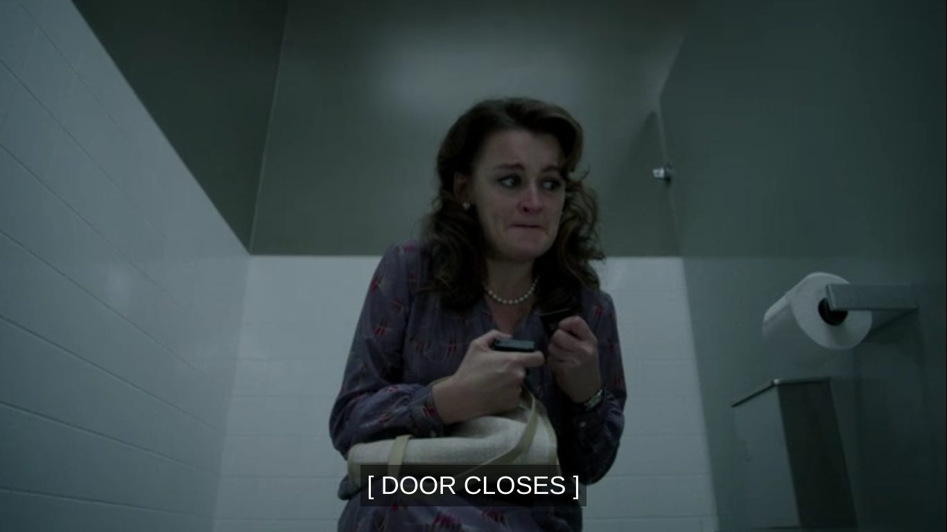 Martha looking scared in a bathroom stall. The closed captioning says [Door Closes]