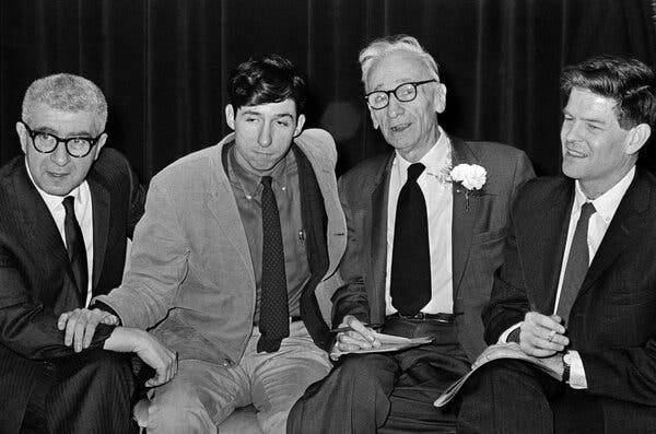 Mr. Lynd and three other men, two of them wearing glasses and one of them much older than the others, sitting together.