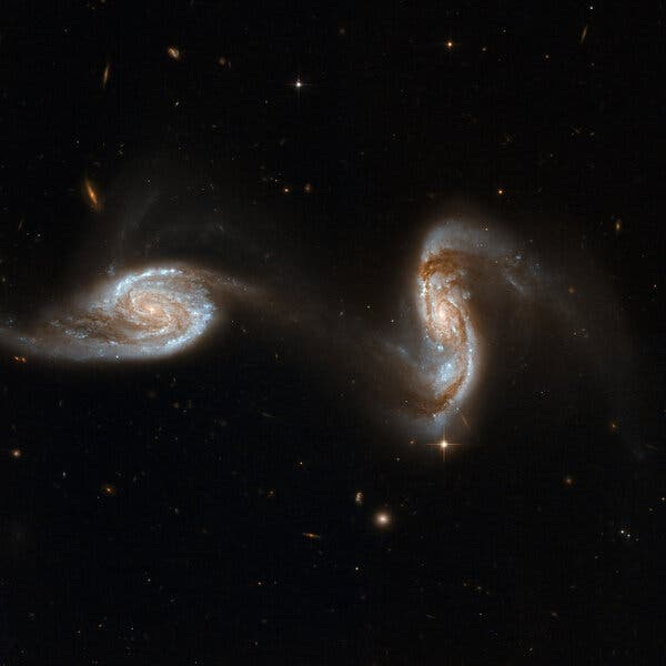 The galaxies NGC 5257 and NGC 5258, each anchored by supermassive black holes at their centers, located in the constellation Virgo, about 300 million light-years away.