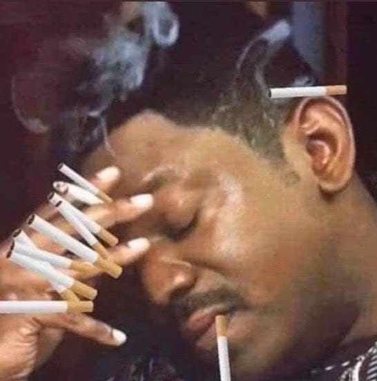 meme of a black man smoking a cigarette with 10 other cigarettes in the pic and holding his head with his hand.