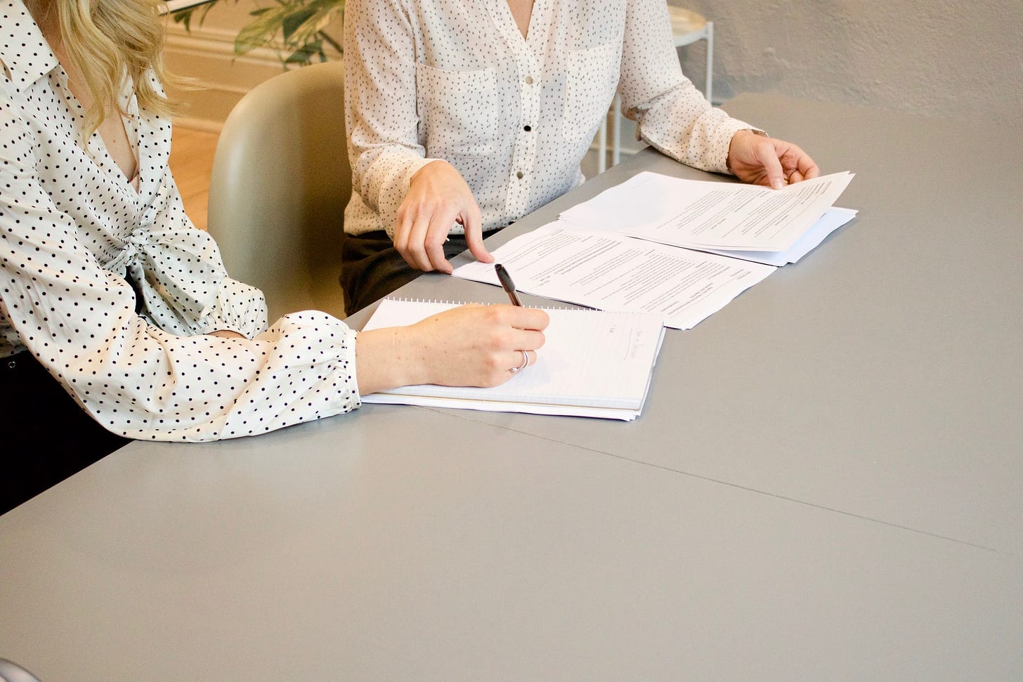 two women discussing signing an agreement