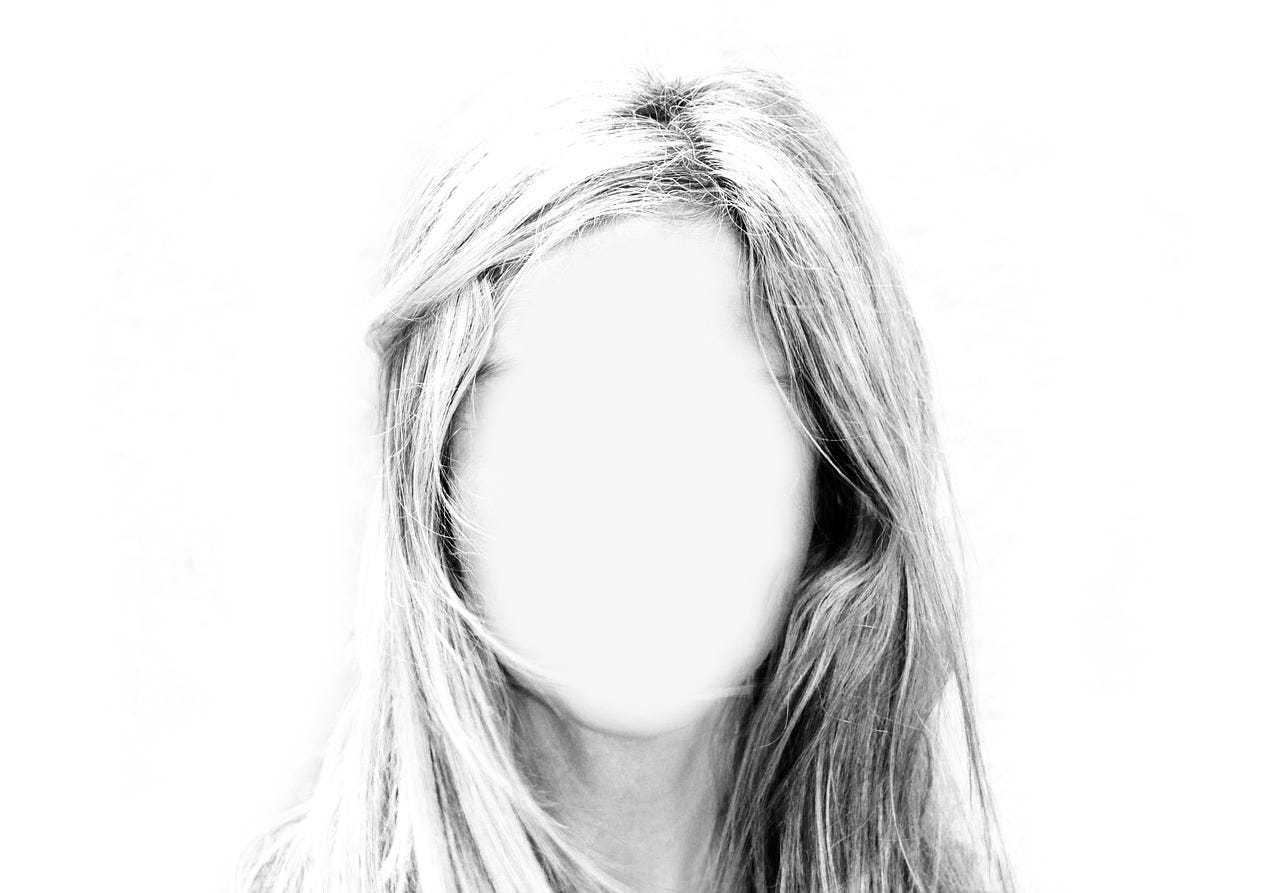 black and white photograph of a woman's head, her face blurred out or missing