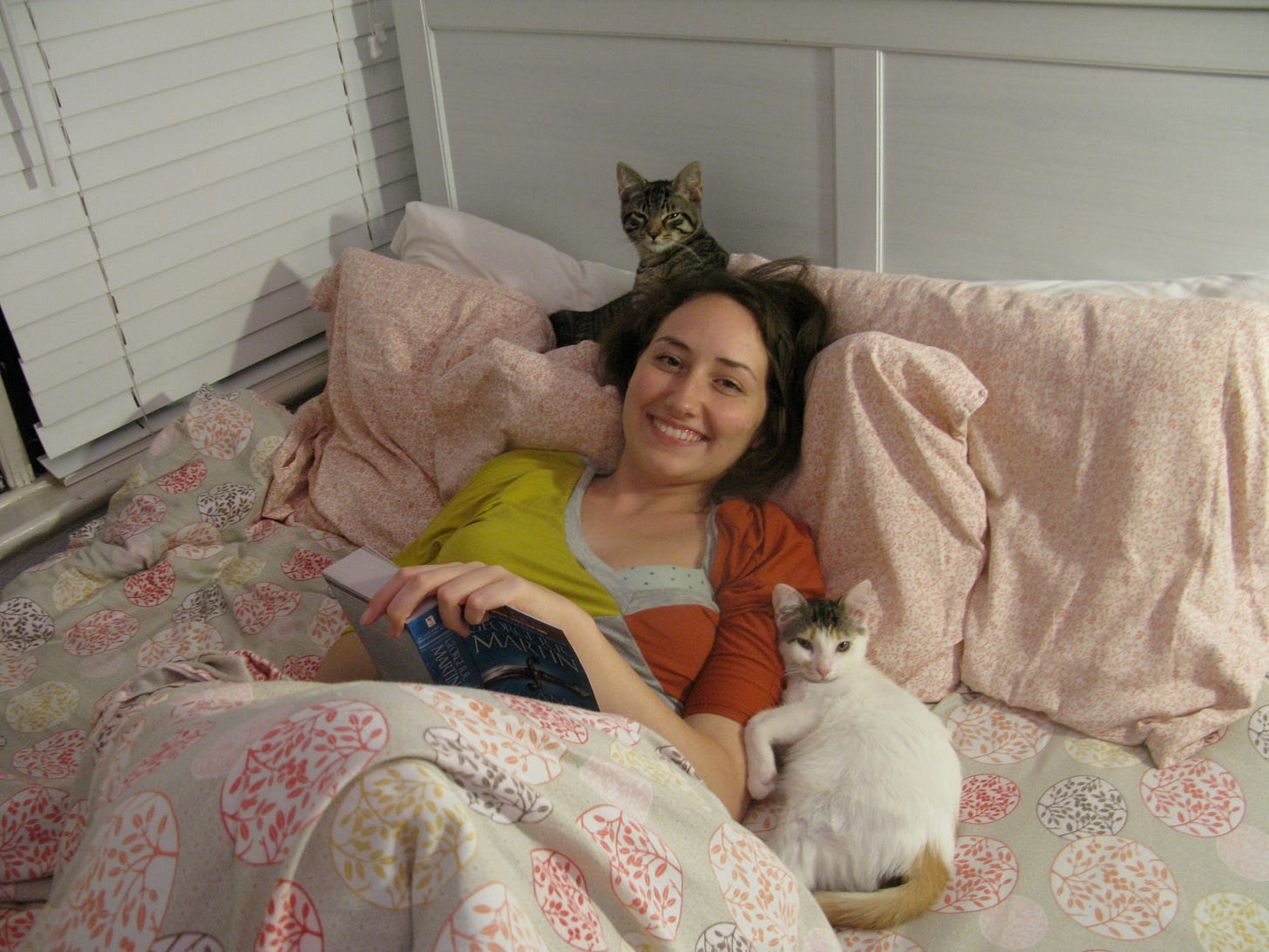 Alli, reading in bed with our two kittens