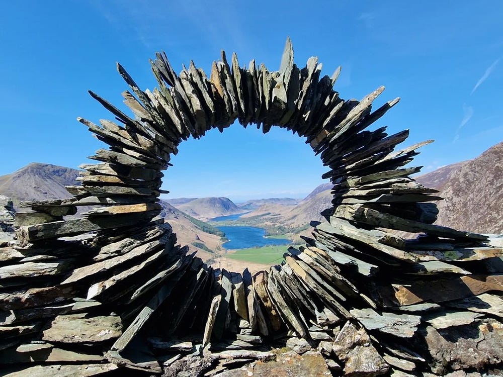 Circular dry stone arch with a view over a lake