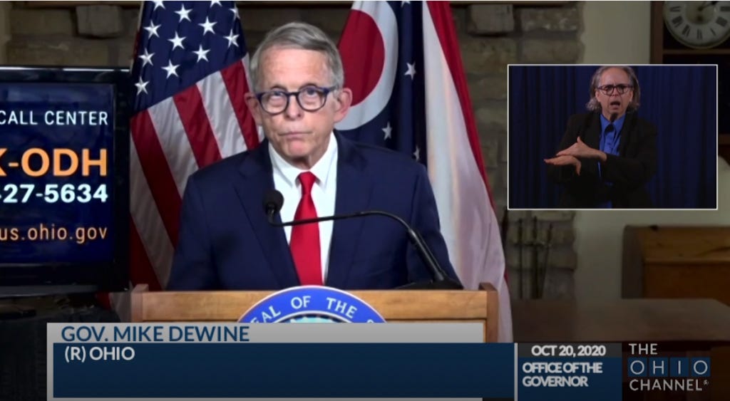 Photo of Mike DeWine at a press conference looking extra droopy