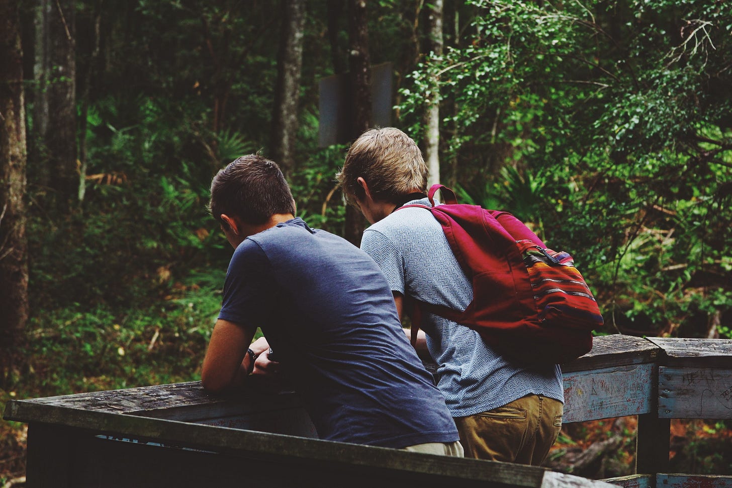 Image of two teenagers leaning on a fence for article titled “comfortable with discomfort” on The Reflectionist