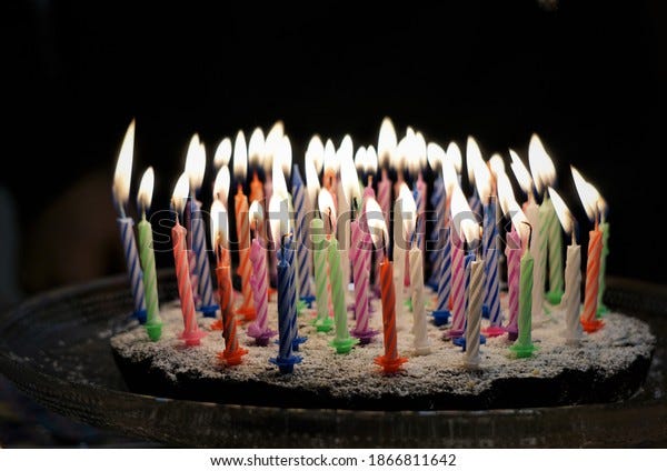 Dark Chocolate Birthday Cake With 53 Candles. Festive Lights Background.